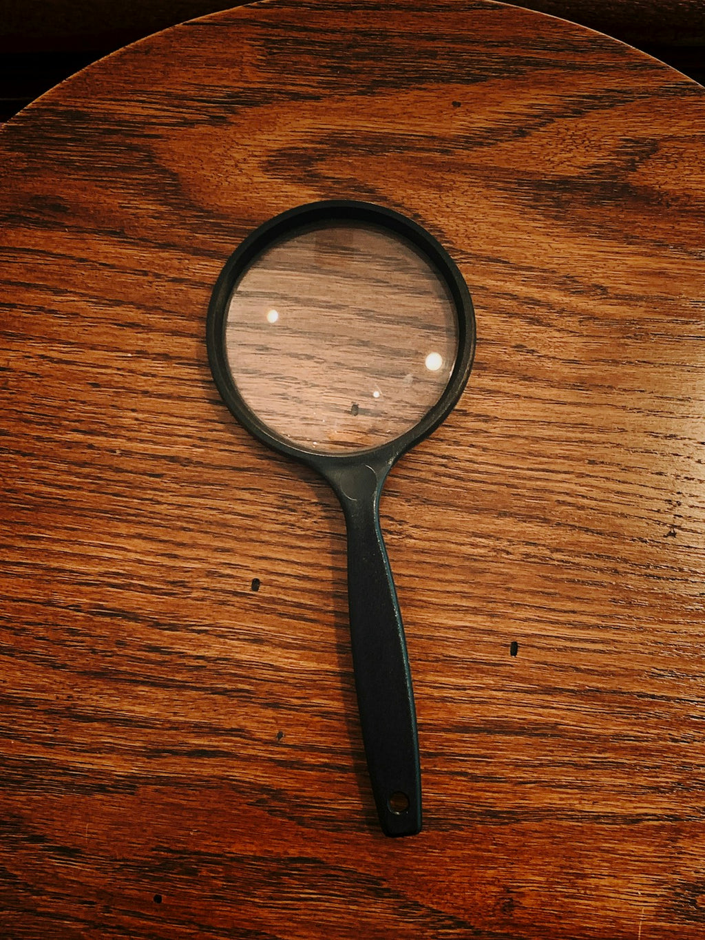 Magnifying glass on wooden surface