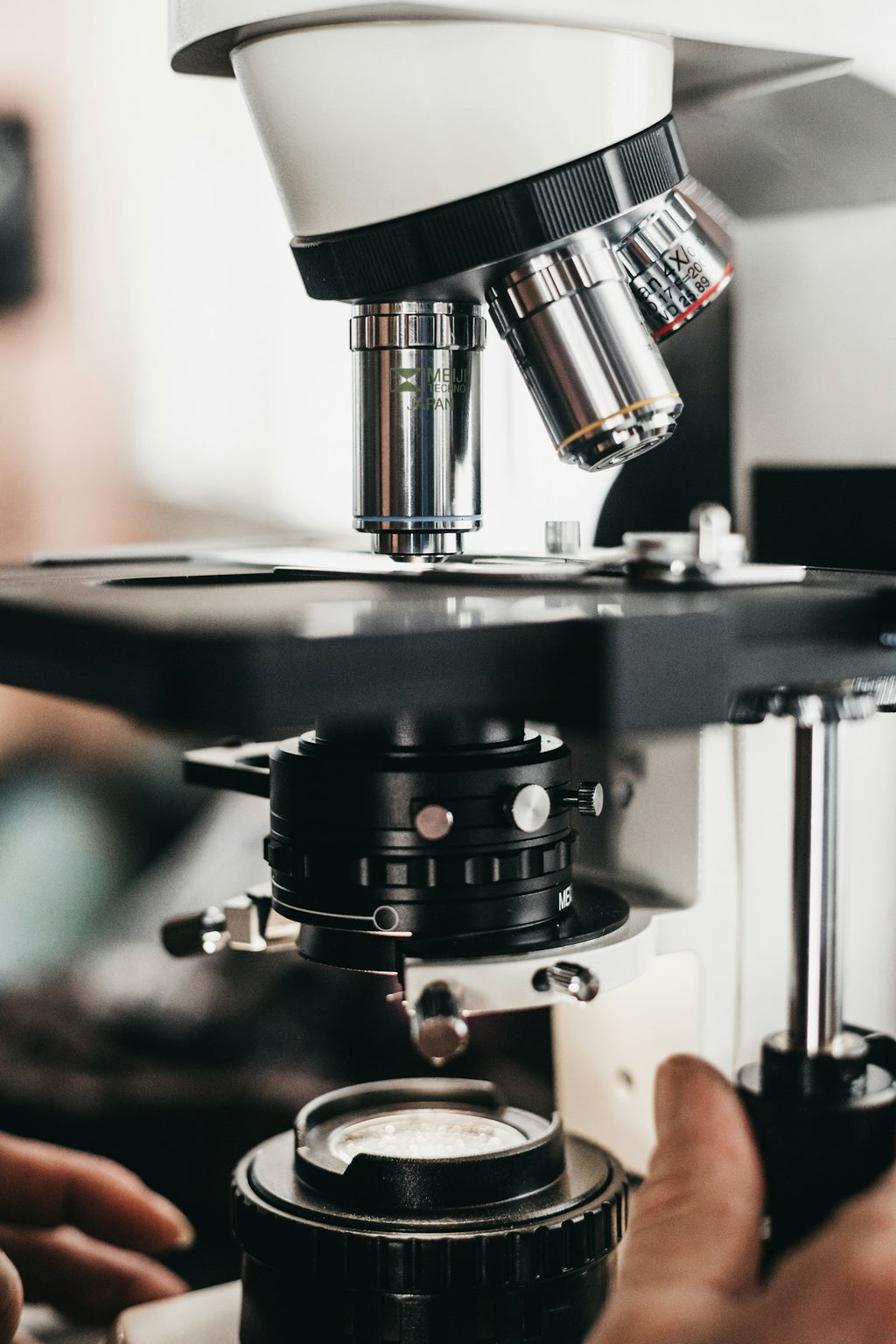 Close-up of compound microscope objective turret with multiple lenses