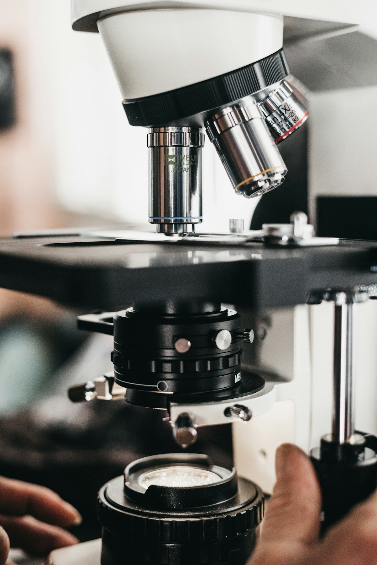 Close-up of compound microscope objective turret with multiple lenses