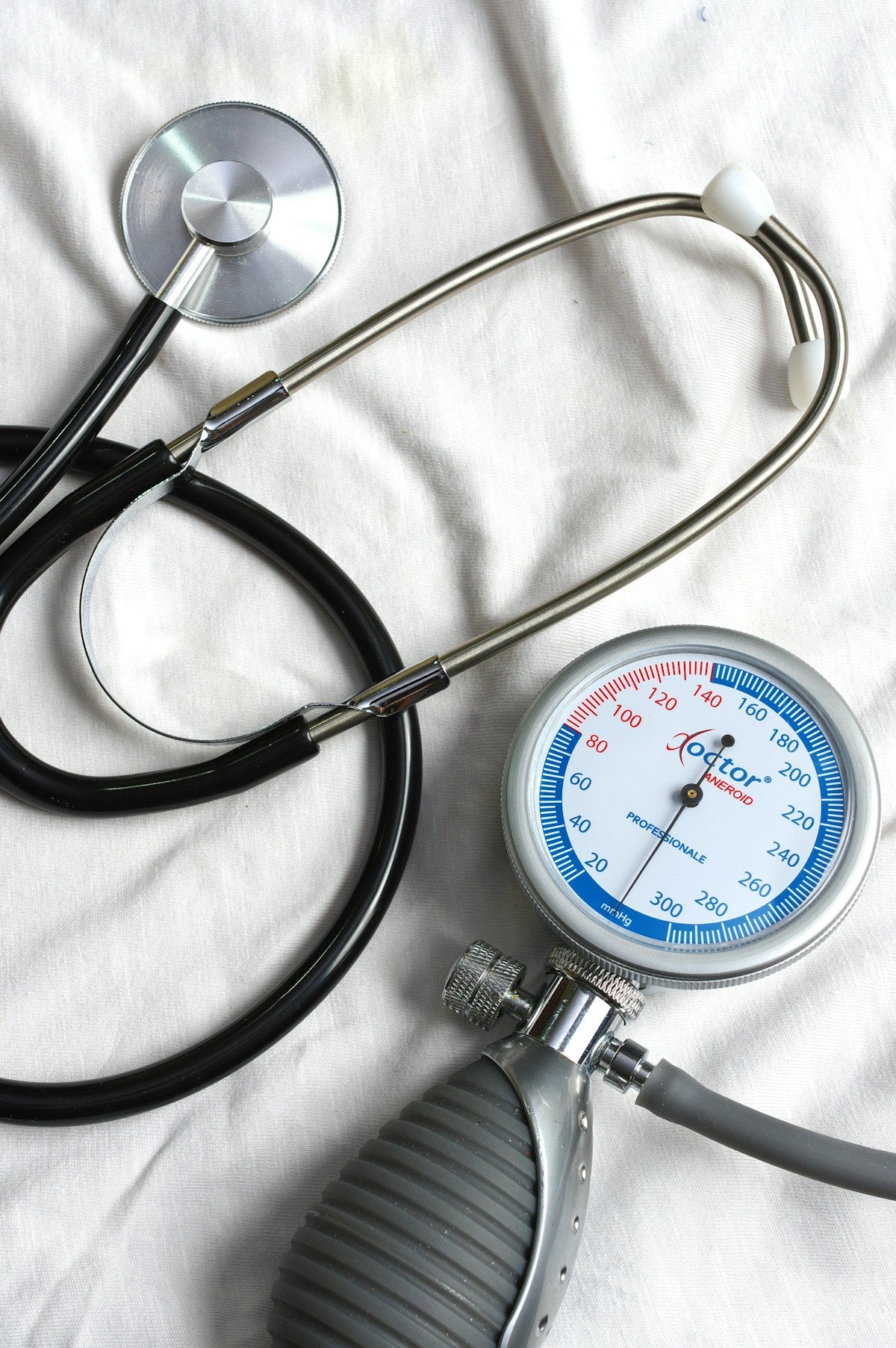 Aneroid sphygmomanometer with stethoscope on white cloth